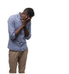 Young african american man wearing blue shirt with sad expression covering face with hands while...