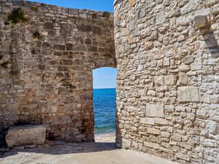 Gate in the city wall of Novigrad with the Adriatic sea in the background. Istria, Croatia, Europe