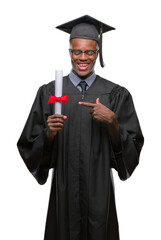 Young graduated african american man holding degree over isolated background very happy pointing with hand and finger