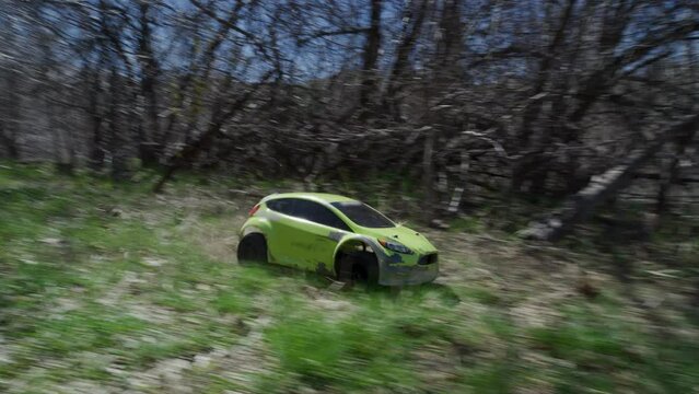 Little green rc car skidding in grass - slow motion