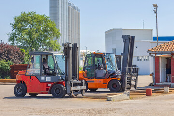 Two Diesel Powered Forklift Trucks at Outside Storage Yard Sunny Day