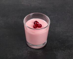 Vegan dessert. Pomegranate cream jelly, Panna Cotta in a glass. Dark background. Close-up