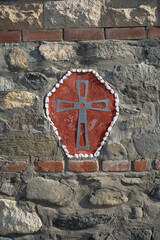 red wall in stone with cross