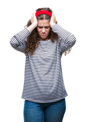 Beautiful brunette curly hair young girl wearing stripes sweater over isolated background suffering from headache desperate and stressed because pain and migraine. Hands on head.