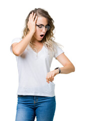 Fototapeta premium Beautiful young blonde woman wearing glasses over isolated background Looking at the watch time worried, afraid of getting late