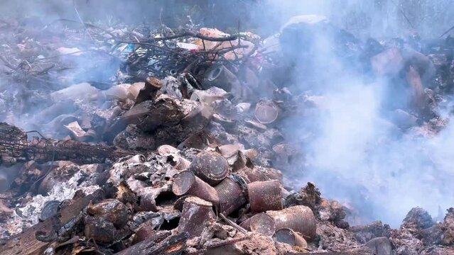 Environmental disaster: plastic waste and toxic garbage burning on a landfill site. Thick smoke and fire flames from burning trash dump. Air pollution, ecological crisis and climate change concept.