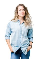 Obraz premium Beautiful young blonde woman over isolated background smiling looking side and staring away thinking.