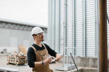 An engineer inspects the construction of grain storage silos. © dsheremeta