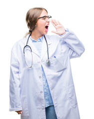 Beautiful young blonde doctor woman wearing medical uniform over isolated background shouting and screaming loud to side with hand on mouth. Communication concept.