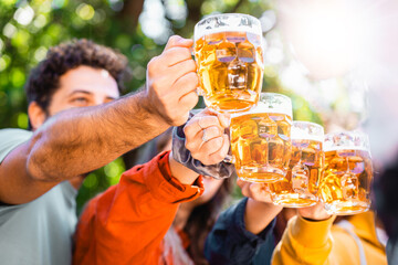 Cheers to Friendship - Friends raise beer mugs in an outdoor toast, basking in sunshine and shared...