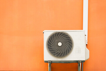 A white air conditioner unit is sitting on a wall