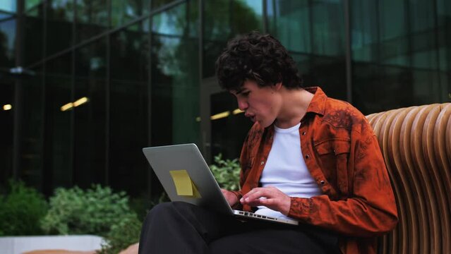 Caucasian man getting very bad news on his laptop computer screen or doing something wrong and feeling disappointed outdoor near moder business office. analysis, concept, economic, sad, stress, crisis