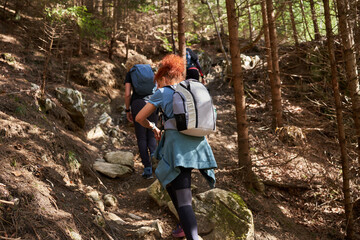 Women hikers with backpacks in the mountains