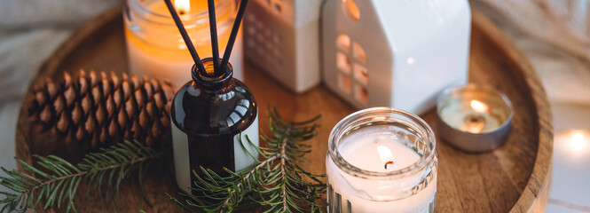 Banner. Christmas home aromatherapy. Cozy atmosphere, holiday spirit. Winter inspiration. Aroma diffuser with pine extract, organic essential oil, vanilla, gingerbread cookies, candles on wooden table