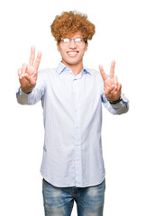 Young handsome business man with afro wearing glasses smiling looking to the camera showing fingers doing victory sign. Number two.