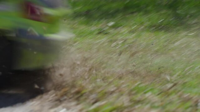 Close up on green rc car driving out of forest