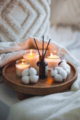 Cozy corner for home meditation, relaxation. Aroma diffuser, burning candles with cotton delicate...