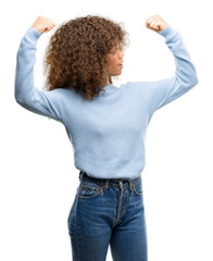 African american woman wearing a sweater showing arms muscles smiling proud. Fitness concept.