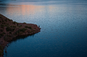 Lonesome fisherman at dawn in Lake Potrerillos, Mendoza, Argentina.