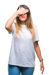 Young beautiful woman casual white t-shirt over isolated background smiling and laughing with hand on face covering eyes for surprise. Blind concept.