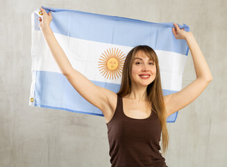 Portrait of happy woman of Argentina match waving a national flag