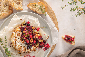Baked or fried grilled Camembert or brie cheese with berry sauce or jam. Gourmet traditional Breakfast close up.