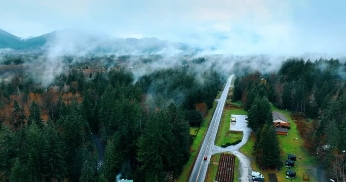 Thick haze covering the scenery of Mount Rainer national Park, Washington State, the USA. Drone footage above the beautiful nature landscape crossed by the highway with one car on.