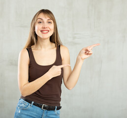 Young happy woman beaming with radiant and joyful smile pointing to side