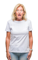 Middle age blonde woman over isolated background afraid and shocked with surprise expression, fear and excited face.