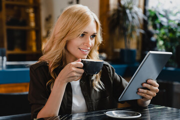 Young caucasian businesswoman using tablet for remote work, e-learning, e-commerce, e-banking,...