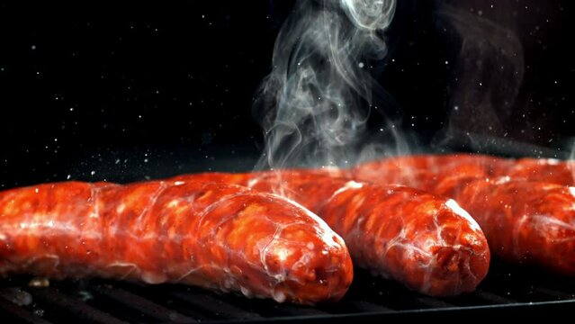 Super slow motion sausages are fried in a pan. High quality FullHD footage