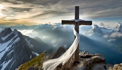 white satin scarf tied around weathered wooden cross on top of a windswept mountain peak overlooking a range of jagged rocky peaks partially obscured by mist