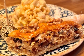 Turkish Baklava dessert with walnuts on a multi colored porcelain plate. Close-up