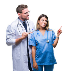 Young couple of doctor and surgeon over isolated background with a big smile on face, pointing with...