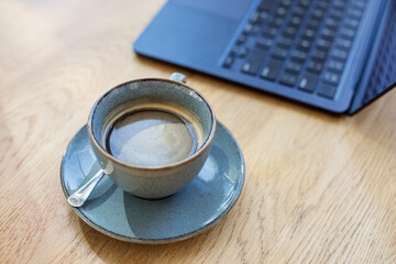 Ceramic Coffee Cup on Wooden Table with Laptop. Workspace.