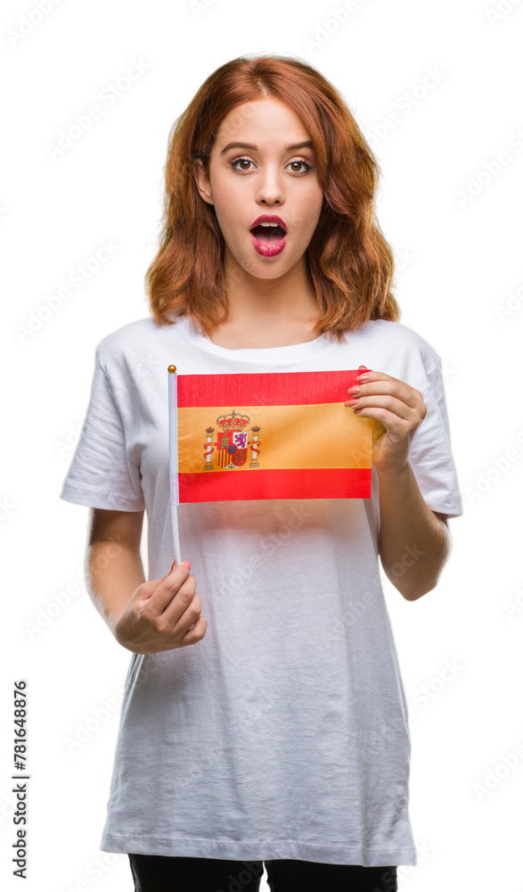 Wall mural Young beautiful woman holding flag of spain over isolated background scared in shock with a surprise face, afraid and excited with fear expression