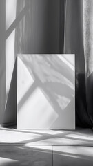 Monochrome image capturing the interplay of light and shadow on a blank canvas and curtain, ideal for branding mockups