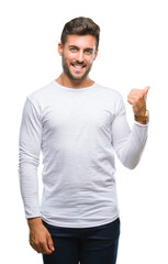 Naklejka premium Young handsome man over isolated background smiling with happy face looking and pointing to the side with thumb up.