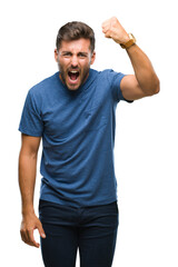 Young handsome man over isolated background angry and mad raising fist frustrated and furious while...