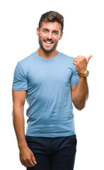 Young handsome man over isolated background smiling with happy face looking and pointing to the...