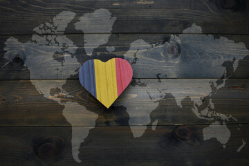 wooden heart with national flag of chad near world map on the wooden background.