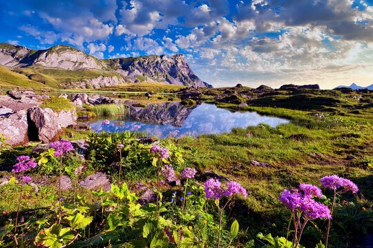 Reflection of the mountains and clouds in the Blausee at sunrise, Melchsee-Frutt, Canton Obwalden, Switzerland, Europe