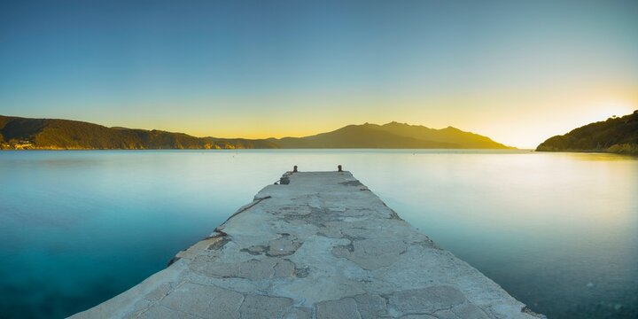 View over the jetty into a bay of the village of Enfola at sunset, evening mood, jetty, island, Elba