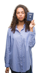 Young hispanic woman holding passport of Germany with a confident expression on smart face thinking serious