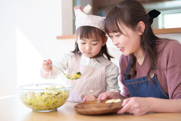 サラダを盛り付ける親子　女の子とお母さん - 781652676