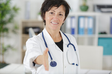 female doctor woman shaking hands with a patient - obrazy, fototapety, plakaty