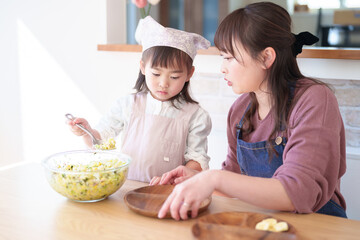 サラダを盛り付ける親子　女の子とお母さん - 781652885
