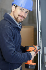 contractor using cordless screwdriver on door frame