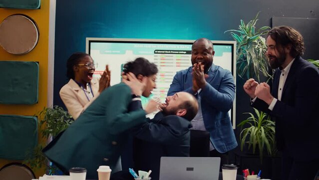 Pleased happy manager celebrating victory and kissing his employee, being in the moment and getting too excited about project success. Supervisor accidentally giving a kiss to his worker. Camera B.