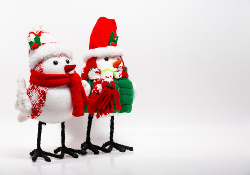 two handcrafted bird Christmas holiday yule decorations wearing scarves winter white background with negative space